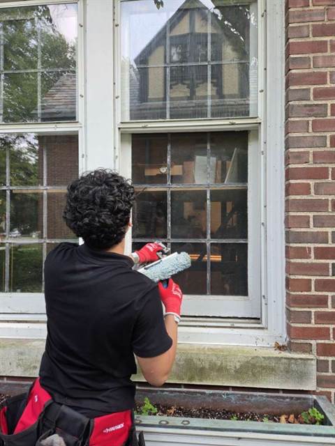 Cleaning a true divided lite window by hand with a microfibre and squeegee.